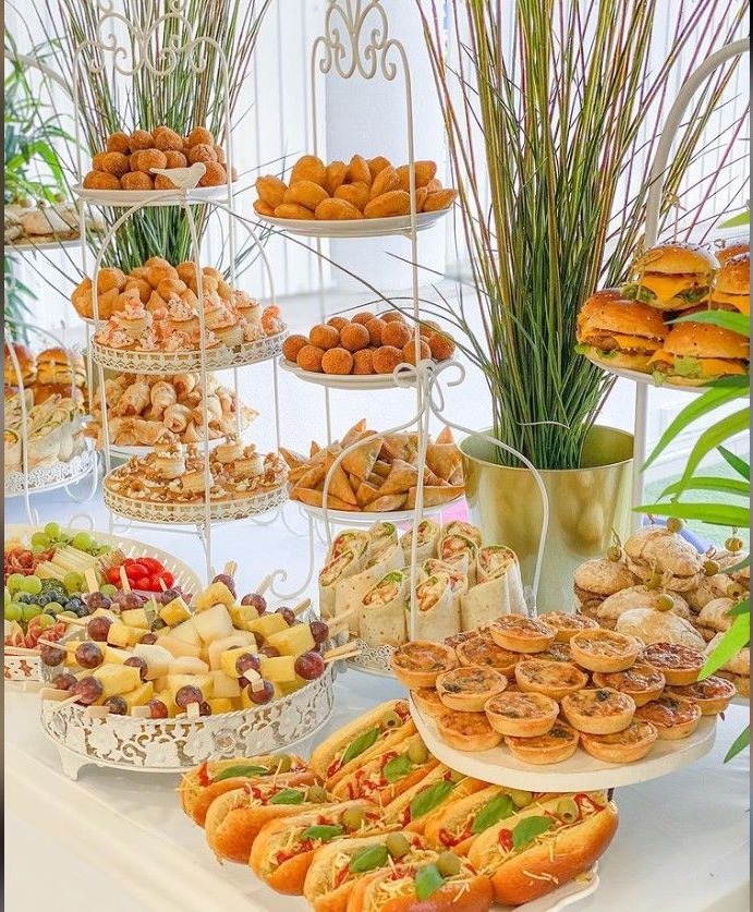 Mesa de brunch com salgados, minissanduíches, frutas e aperitivos